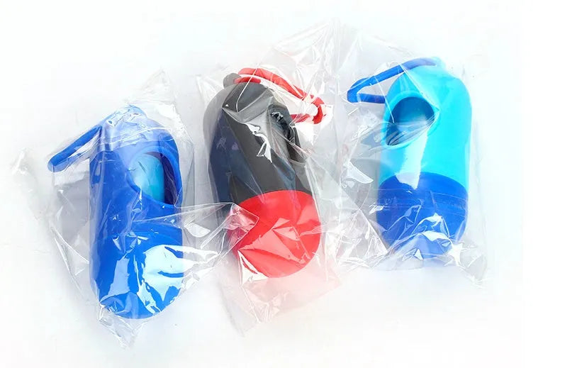 Set of five rolled pet waste bags in assorted colours on a green background.