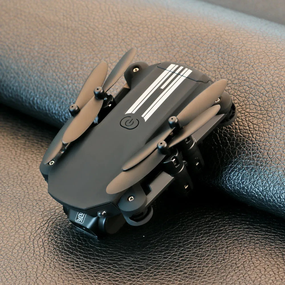 Mini folding aerial drone with 4K camera, black, arms open showing four propellers, compact body on white background