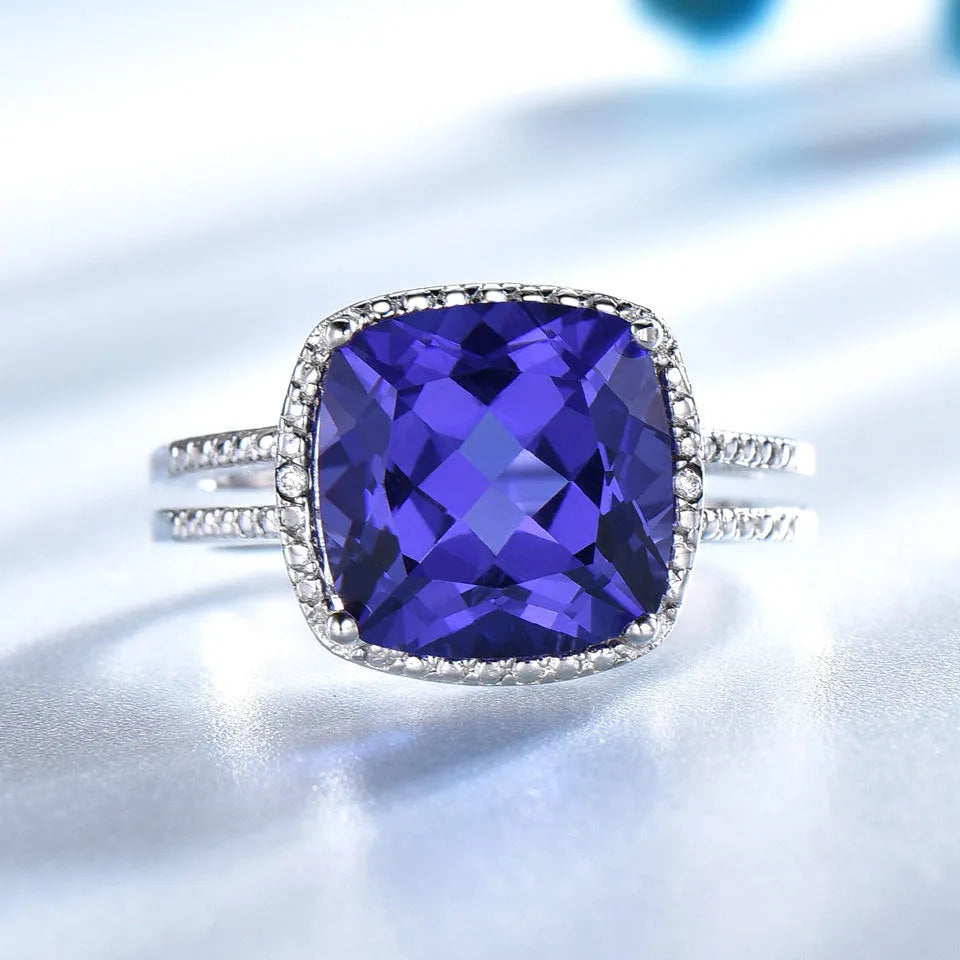 Blue Tanzanite stone set in a sterling silver 925 ring for women, shown on a finger.