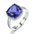 Blue Tanzanite stone set in a sterling silver 925 ring for women, shown on a finger.