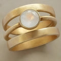 Gold plated geometric titanium steel ring with micro-inlaid white chalcedony detail showing linear design elements