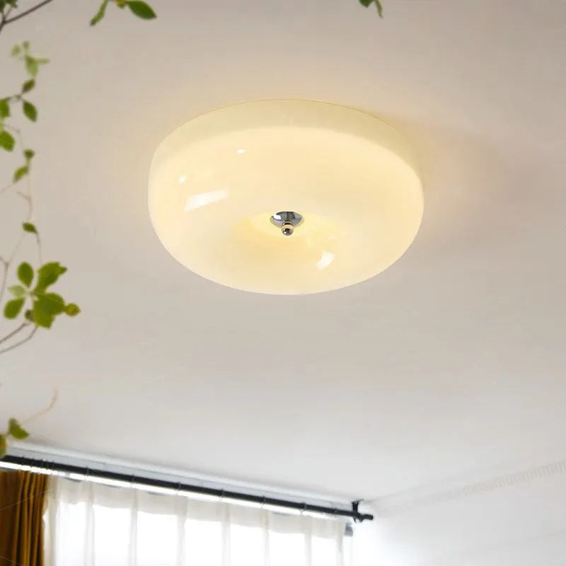 American-style antique finish ceiling lamp with cream coloured shade in bedroom setting