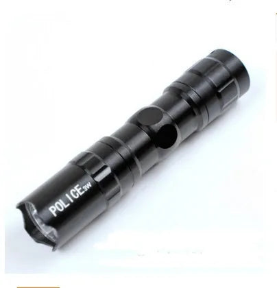 Small black aluminium alloy LED mini flashlight showing scale next to a AA battery.