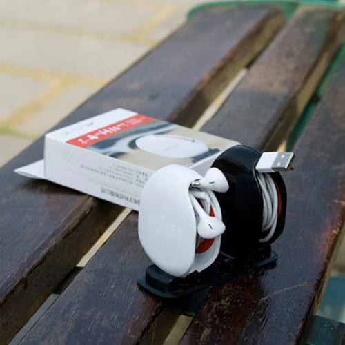 Automatic earphone cable retractor winder in a compact plastic storage box.