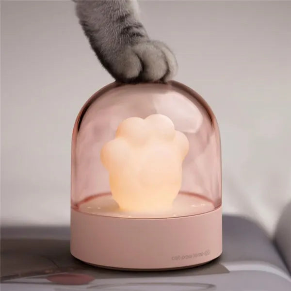 Grey cat paw shaped USB night light with rotating soft light and music box function on wooden desk