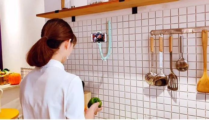 Flexible black rubber phone holder with suction cup wrapped around a bicycle handlebar, showing a phone mounted at an angle.