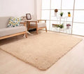 Solid colour plush area rug in a rectangle shape on a wooden floor
