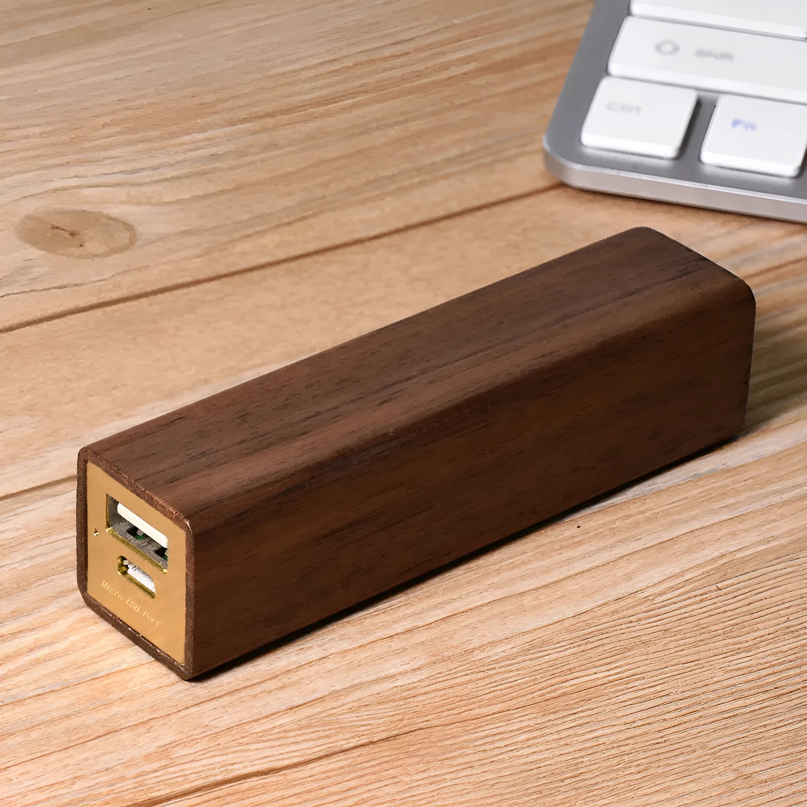 Black walnut wood portable power bank showing natural grain, with dimensions 100mm by 25mm.