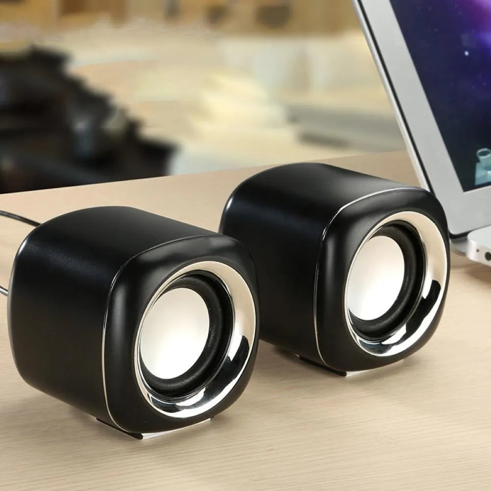 Compact black desktop speakers with 3.5mm cable and volume scroll wheel