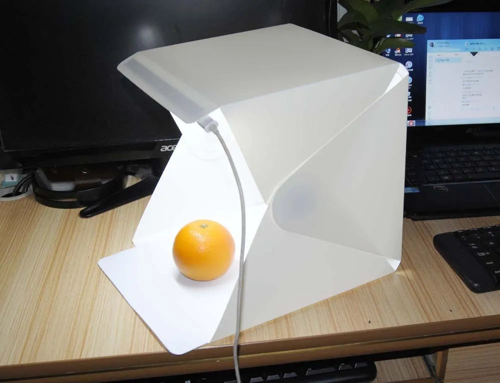 40cm folding studio LED soft light box with adjustable colour temperature and six colourful background cloths laid out.