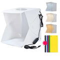 40cm folding studio LED soft light box with adjustable colour temperature and six colourful background cloths laid out.