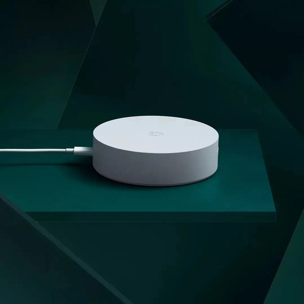 White circular Xiaomijia smart home gateway with UK plug for wall mounting.
