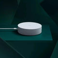 White circular Xiaomijia smart home gateway with UK plug for wall mounting.