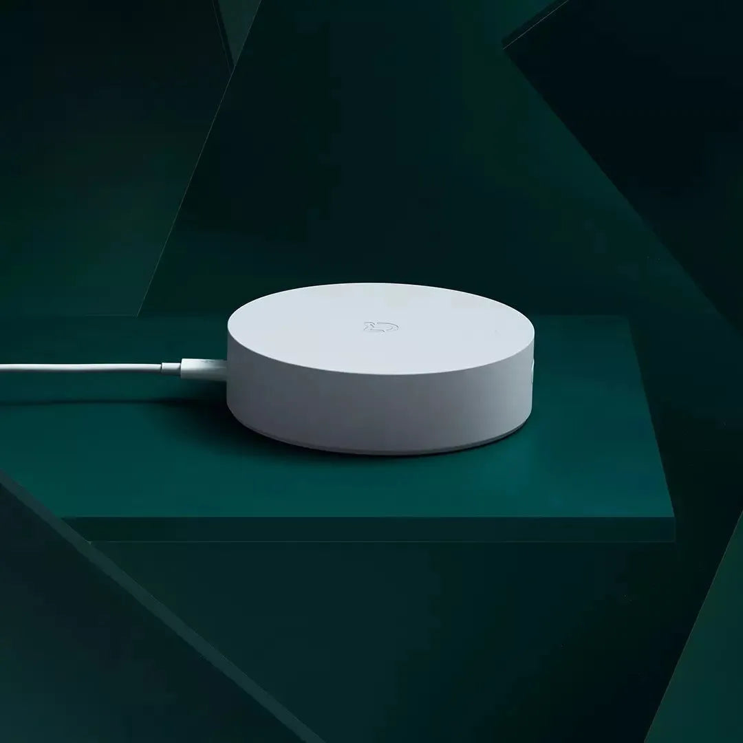 White circular Xiaomijia smart home gateway with UK plug for wall mounting.