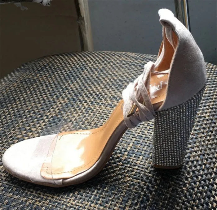 Women's black and gold pointed-toe plastic high heels on a white background