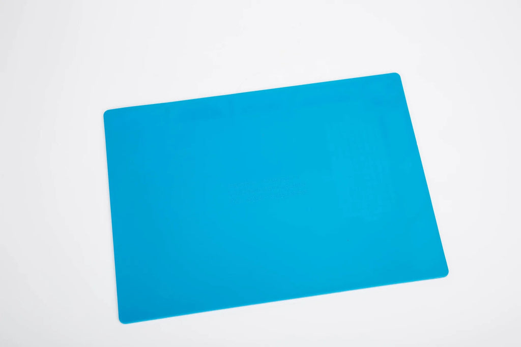 Blue silicone anti-skid pad for watch repair on a workbench, showing non-slip surface