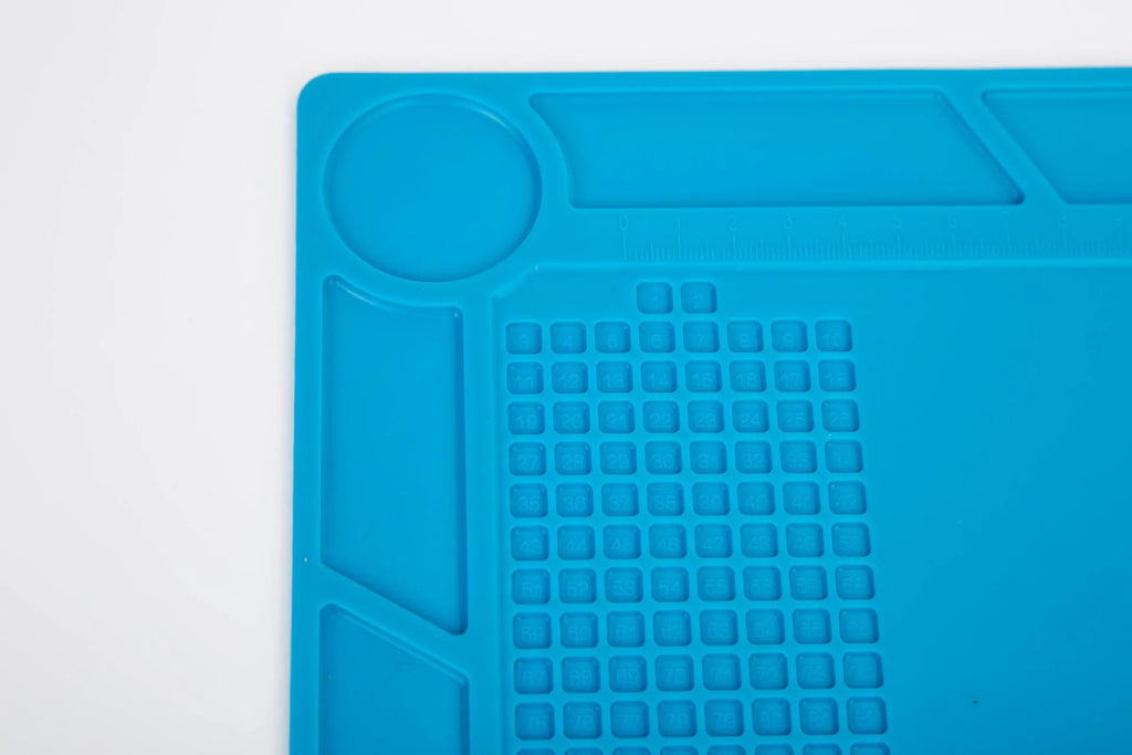 Blue silicone anti-skid pad for watch repair on a workbench, showing non-slip surface