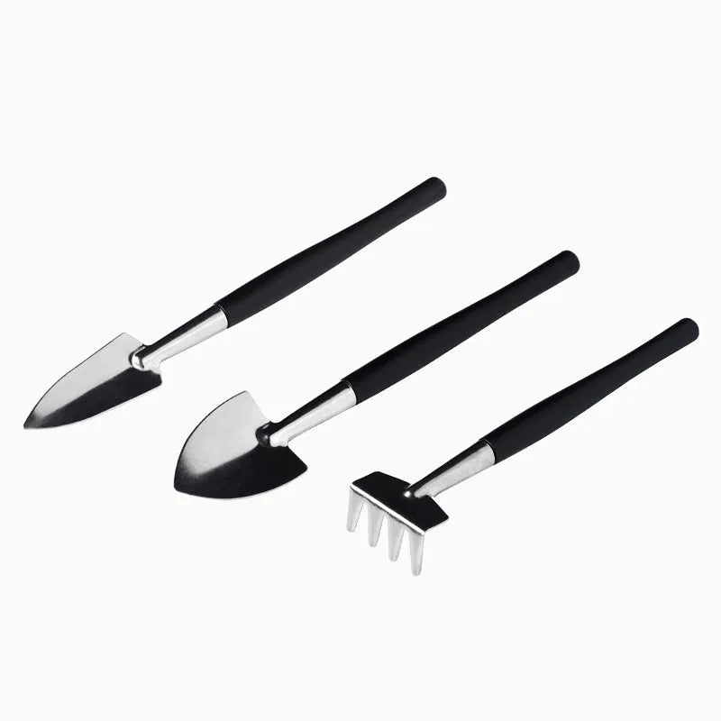 Black mini succulent garden tool set showing scissors, tweezers, shovels, rake, watering bottles, and a cushion for small plant care.