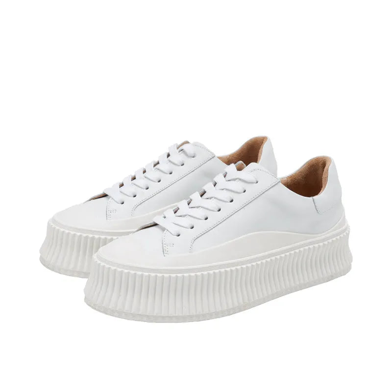 Women's black suede platform lace-up trainers with chunky rubber sole and cross-binding detail on the upper.