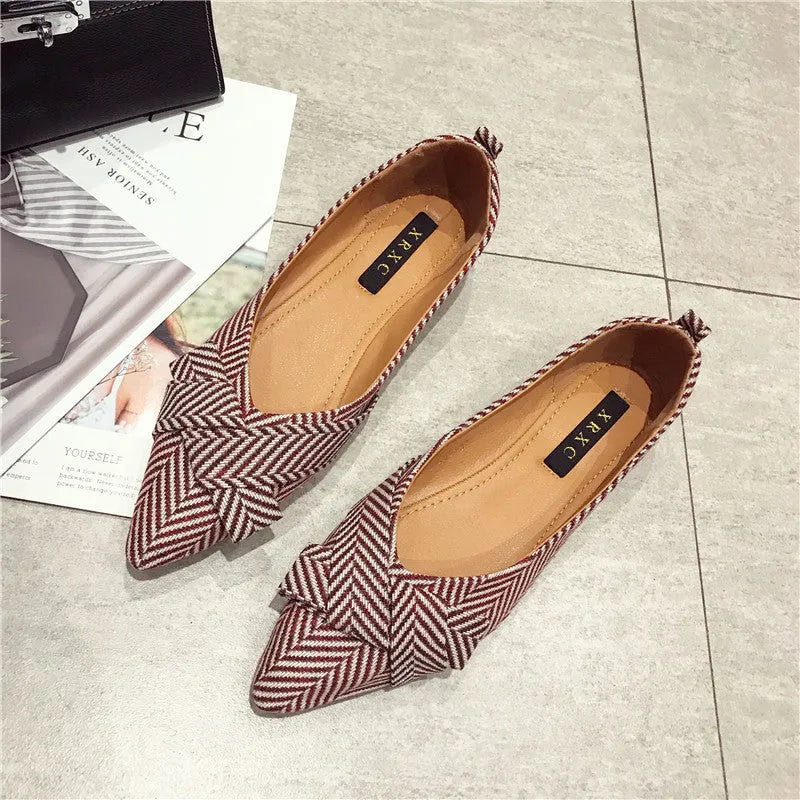Women's pointed toe single shoes in black or red with shallow mouth design and low flat heel