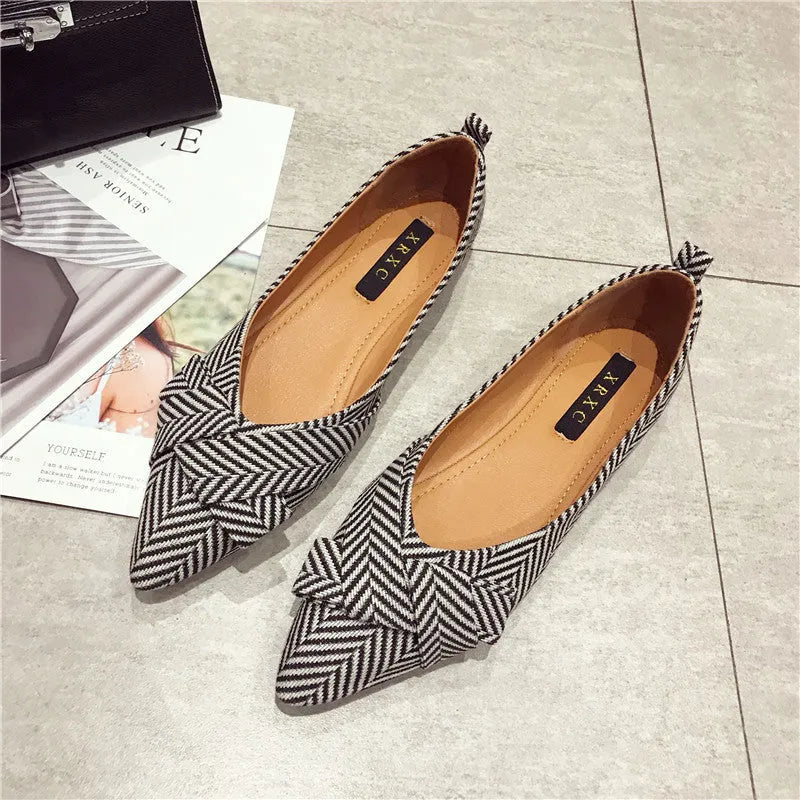 Women's pointed toe single shoes in black or red with shallow mouth design and low flat heel