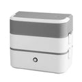 Pink and white portable heated lunch box with plug and push-button control.
