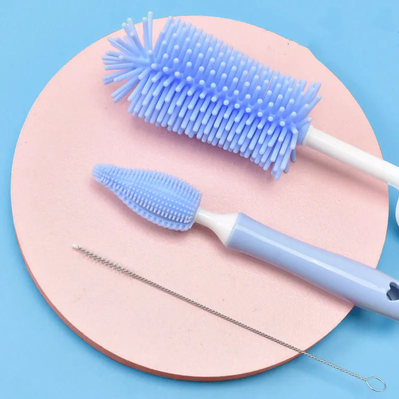 Silicone baby bottle cleaning brush and separate straw cleaner in pink, blue, and yellow colours.