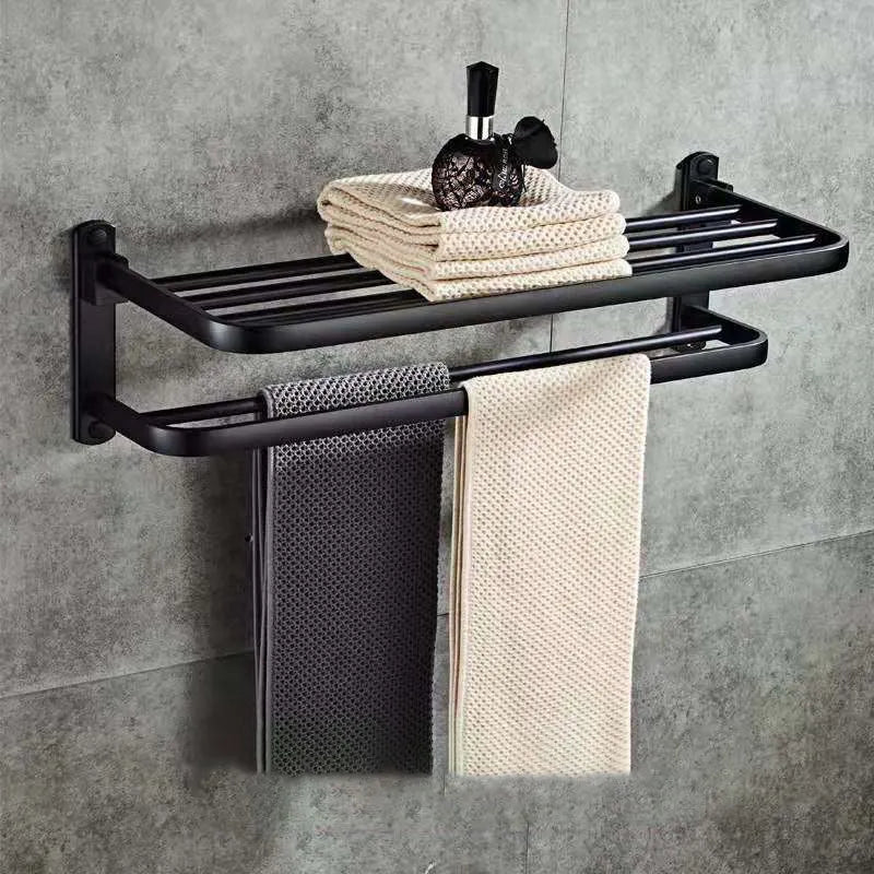 Silver aluminium double-decker folding bathroom shelf with towels, mounted on a wall.