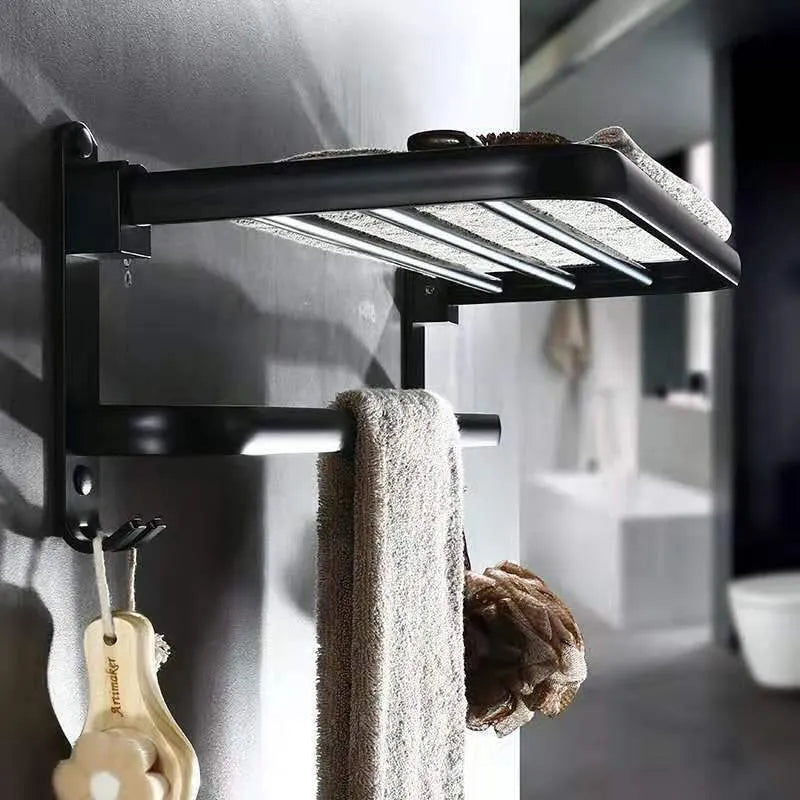 Silver aluminium double-decker folding bathroom shelf with towels, mounted on a wall.