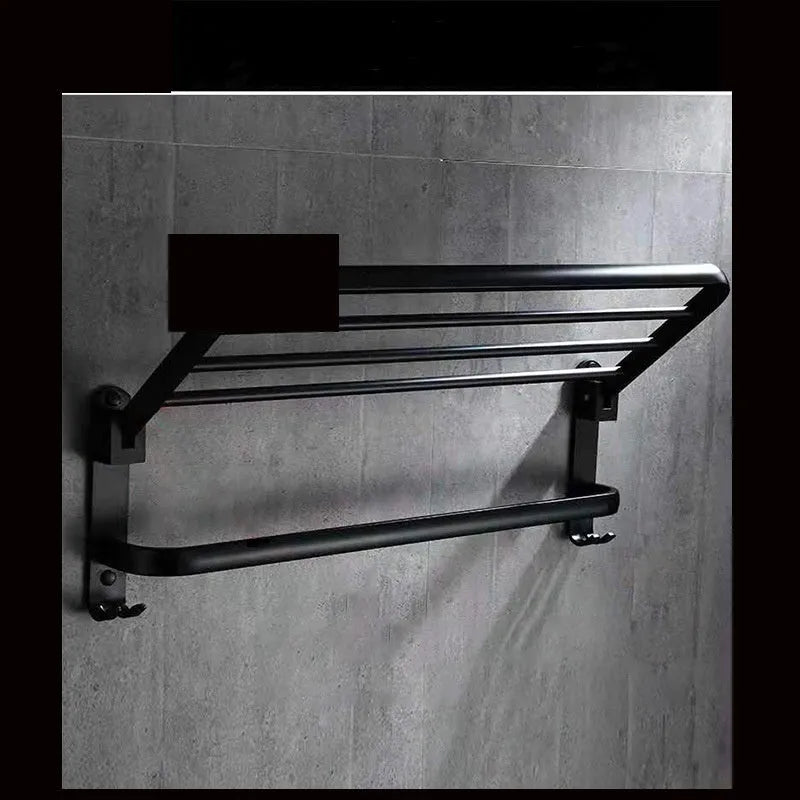 Silver aluminium double-decker folding bathroom shelf with towels, mounted on a wall.