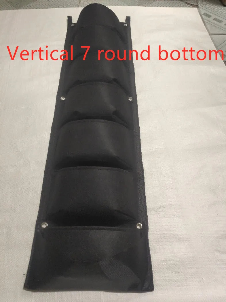 Vertical wall garden planting bag with multiple pockets for herbs and flowers hanging on fence