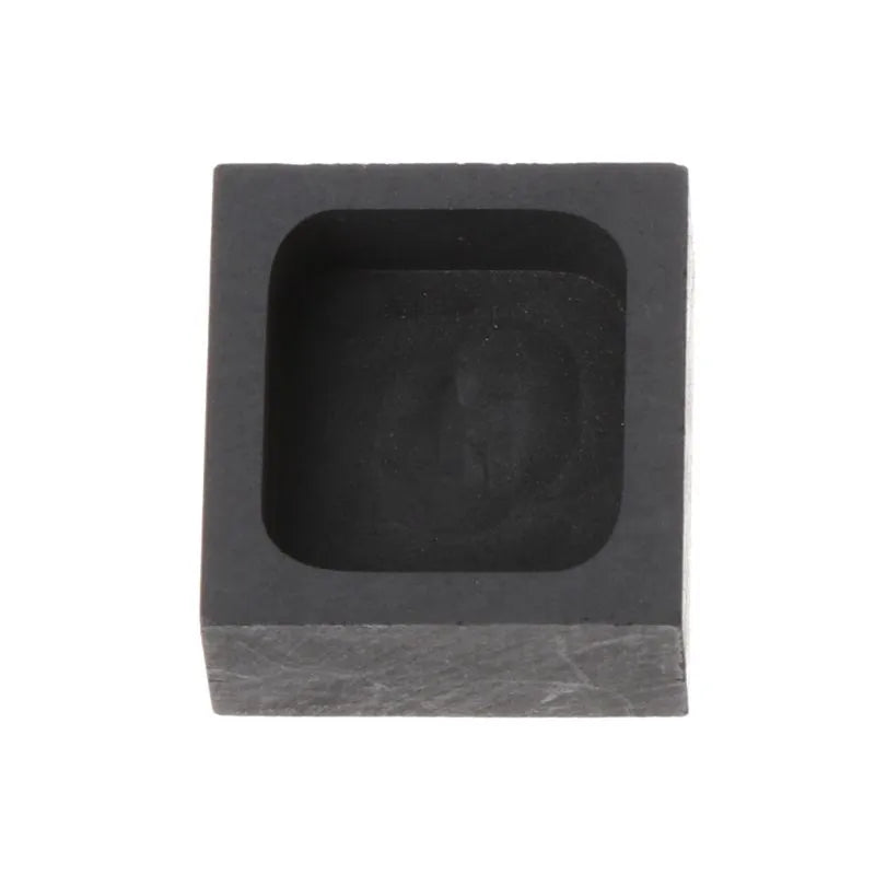 Square high-purity graphite crucible for melting gold, silver, and platinum on a work surface.