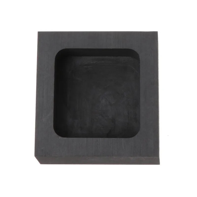 Square high-purity graphite crucible for melting gold, silver, and platinum on a work surface.