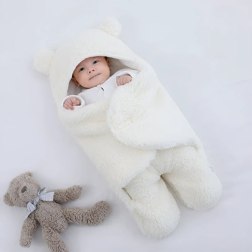 Baby quilted sleeping bag wrapper in cotton blend fabric, shown in grey colour with size tag.
