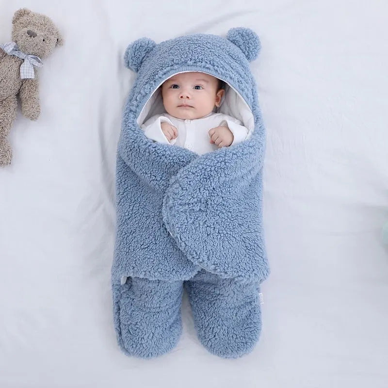 Baby quilted sleeping bag wrapper in cotton blend fabric, shown in grey colour with size tag.