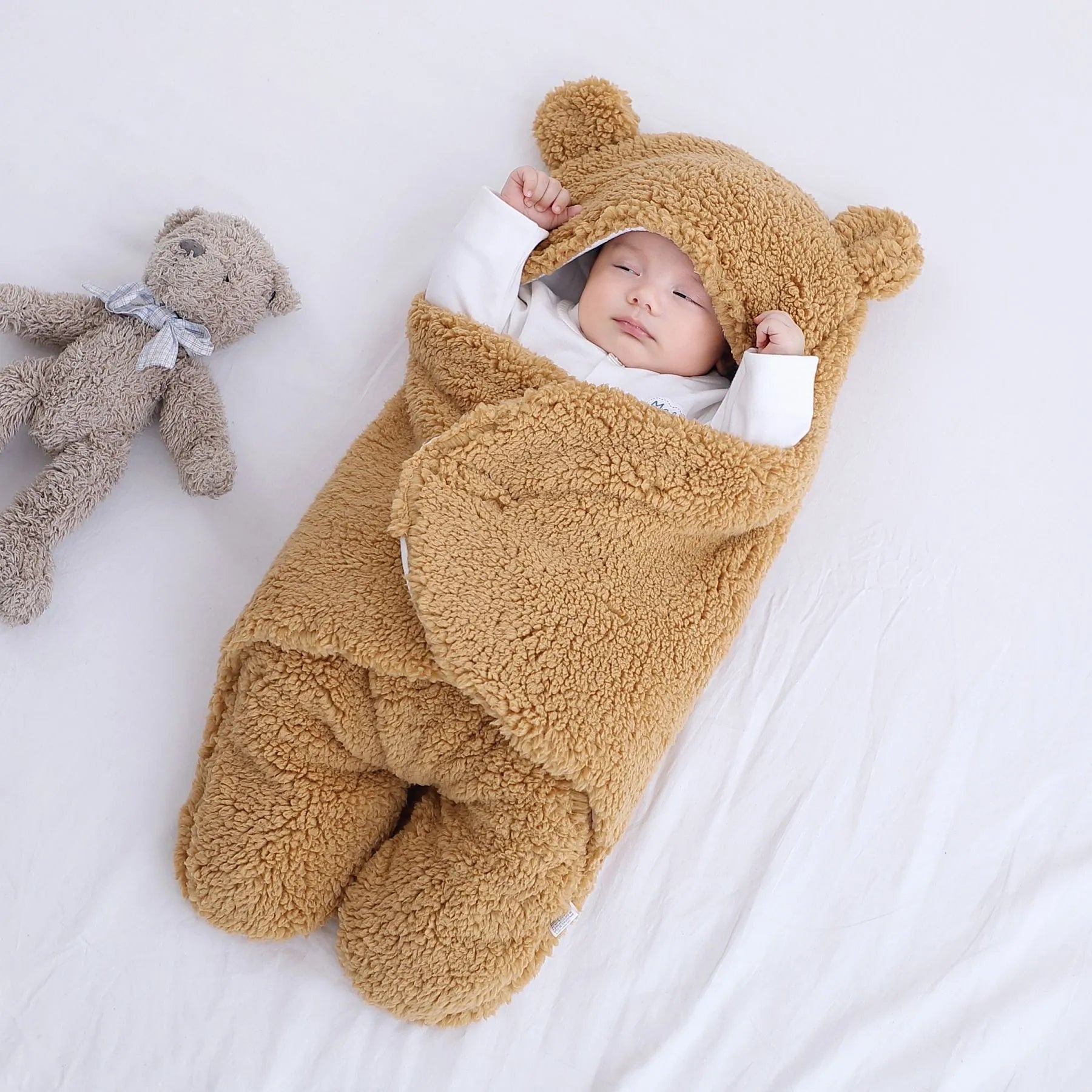Baby quilted sleeping bag wrapper in cotton blend fabric, shown in grey colour with size tag.