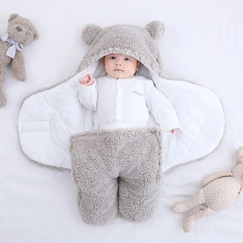 Baby quilted sleeping bag wrapper in cotton blend fabric, shown in grey colour with size tag.