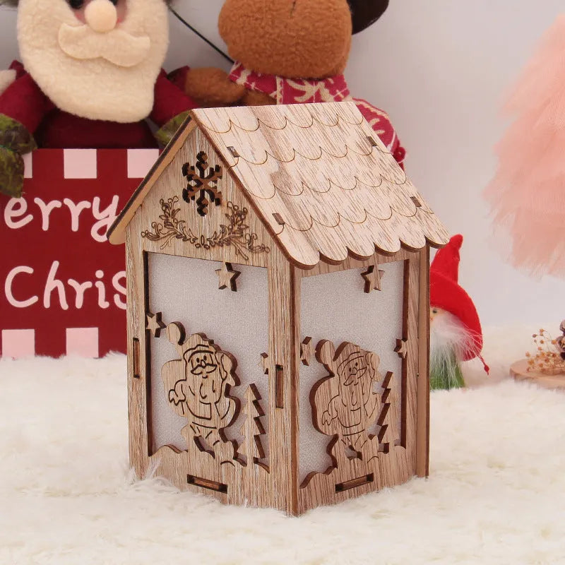 Three handcrafted wooden Christmas house decorations on a rustic table: a log bell, a painted old man cottage, and a snowman house.