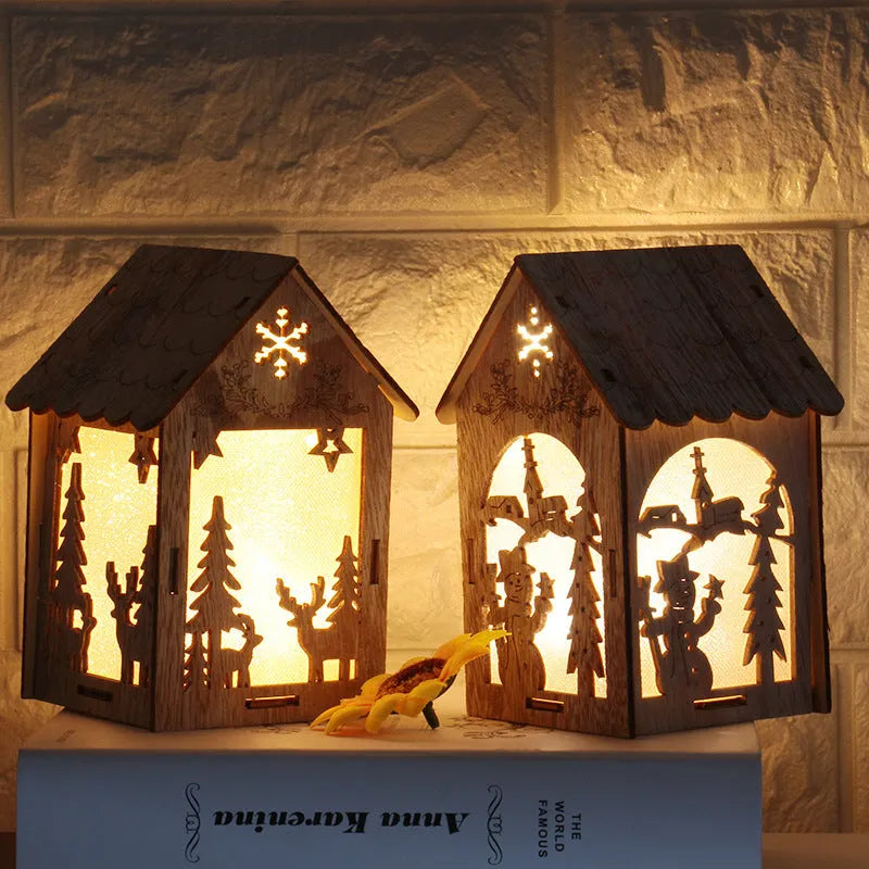 Three handcrafted wooden Christmas house decorations on a rustic table: a log bell, a painted old man cottage, and a snowman house.