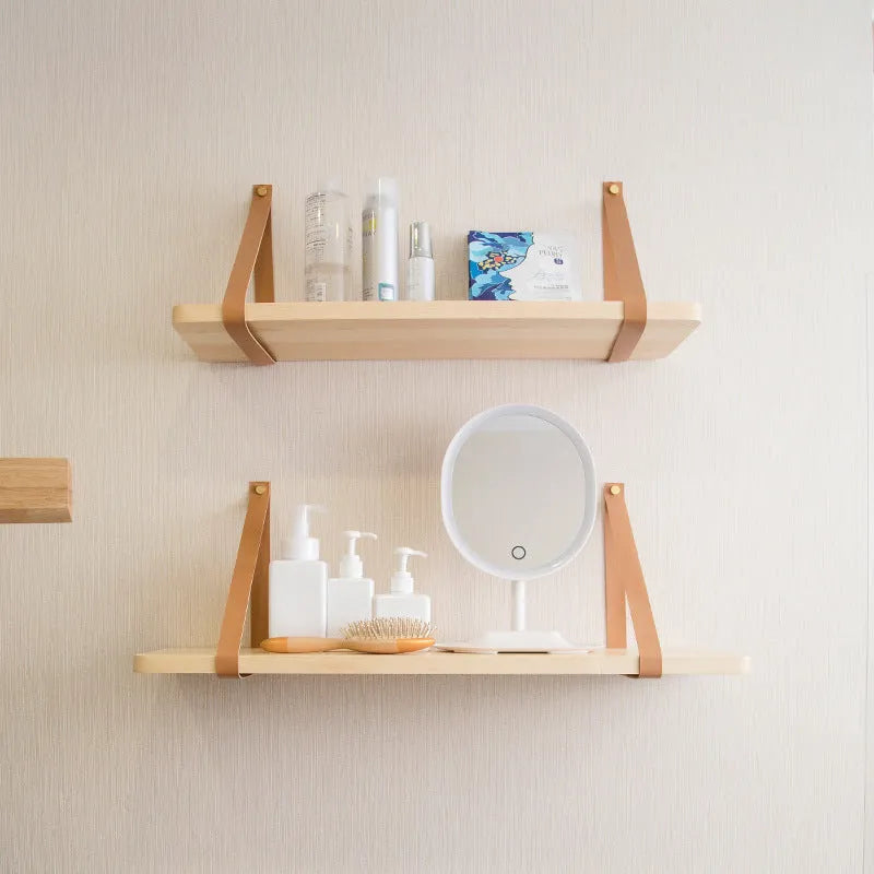 Natural pine wood wall-mounted shelf in Nordic style for organising remotes, books, and cosmetics.