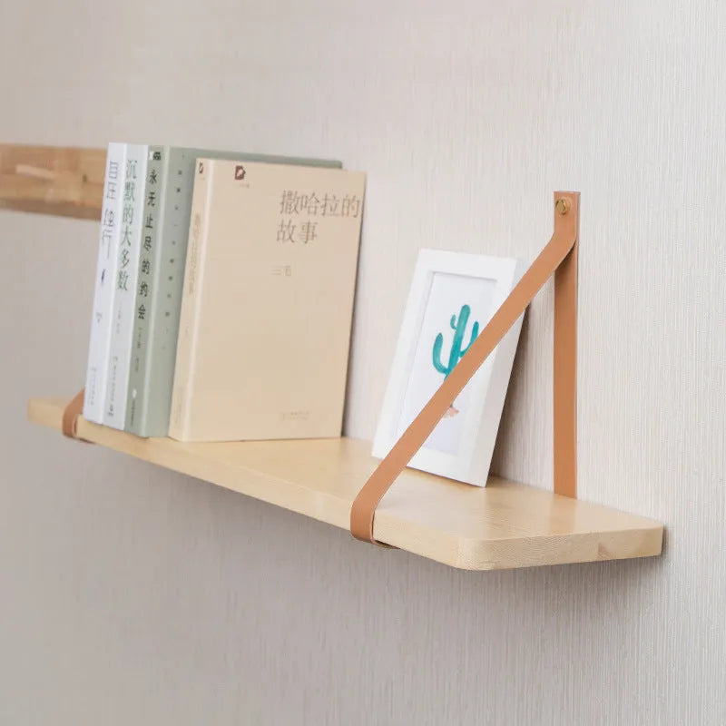 Natural pine wood wall-mounted shelf in Nordic style for organising remotes, books, and cosmetics.