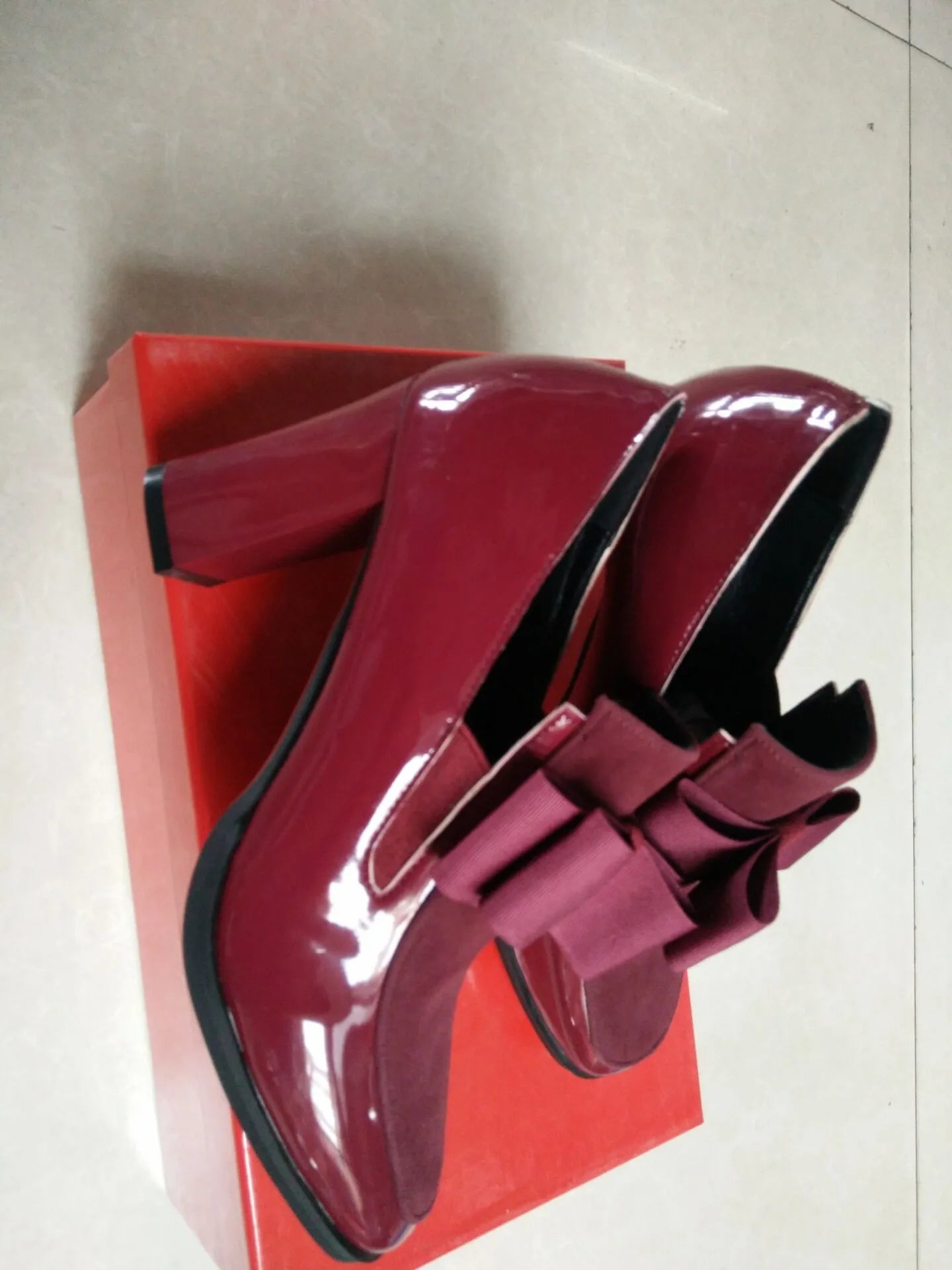 Black patent leather women's high-heel shoes with a thick heel and square toe.