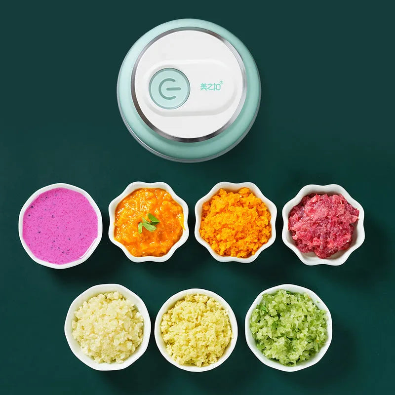 Portable electric mini garlic cutter with transparent cup and stainless steel blade on kitchen counter