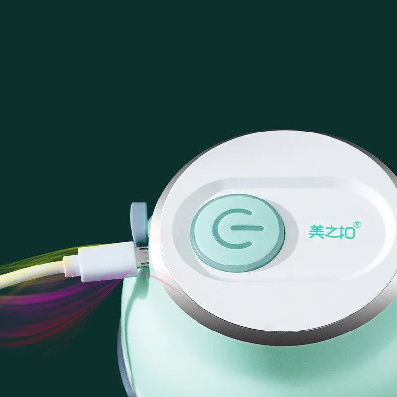 Portable electric mini garlic cutter with transparent cup and stainless steel blade on kitchen counter