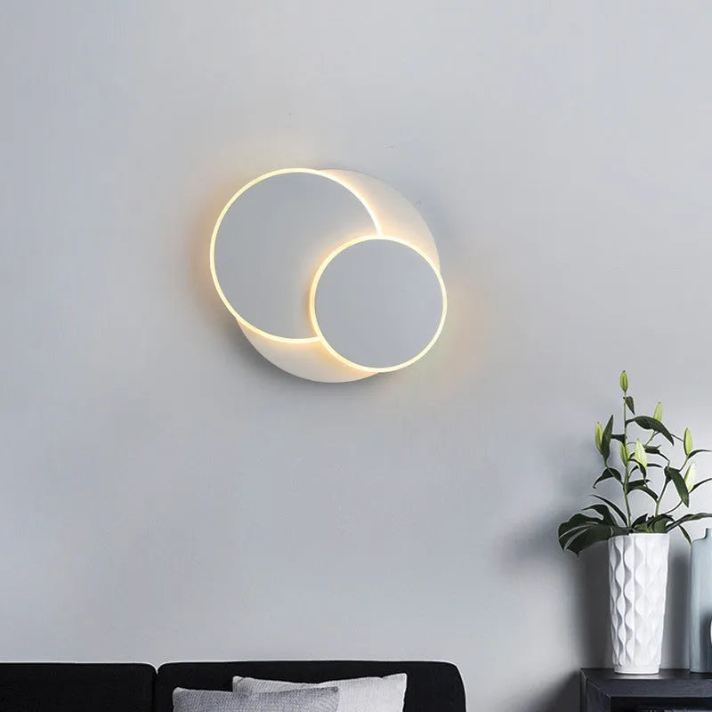 Modern round acrylic wall lamp in black or white, shown in large, medium and small sizes.