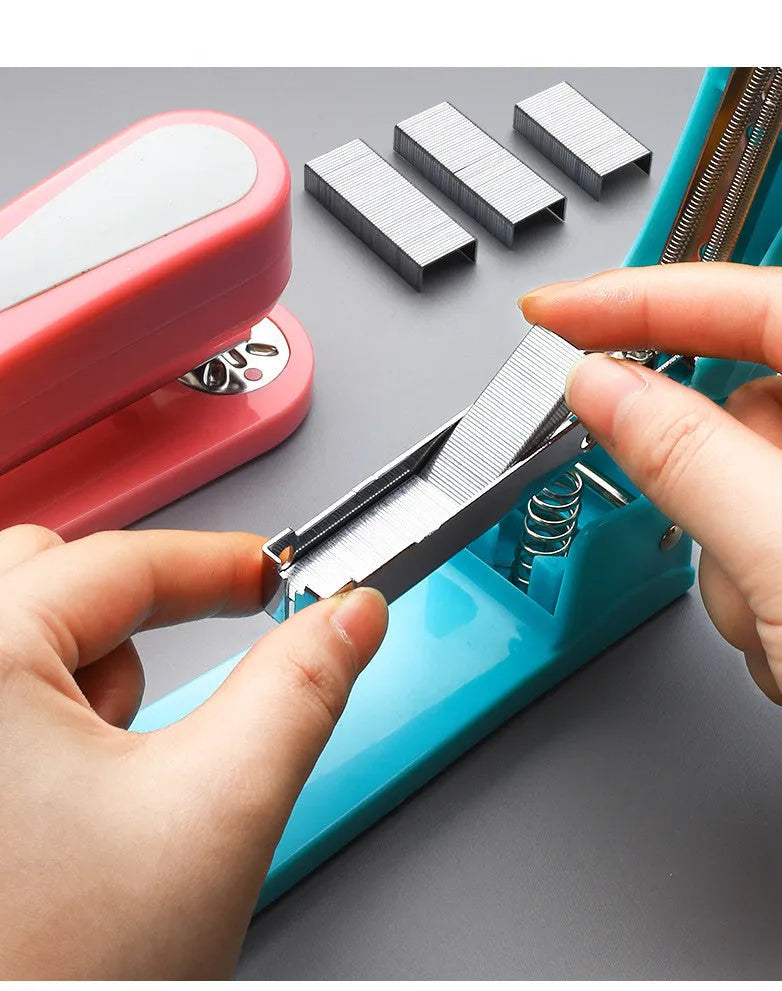 360-degree rotatable student stapler in multiple colours on a desk with paper