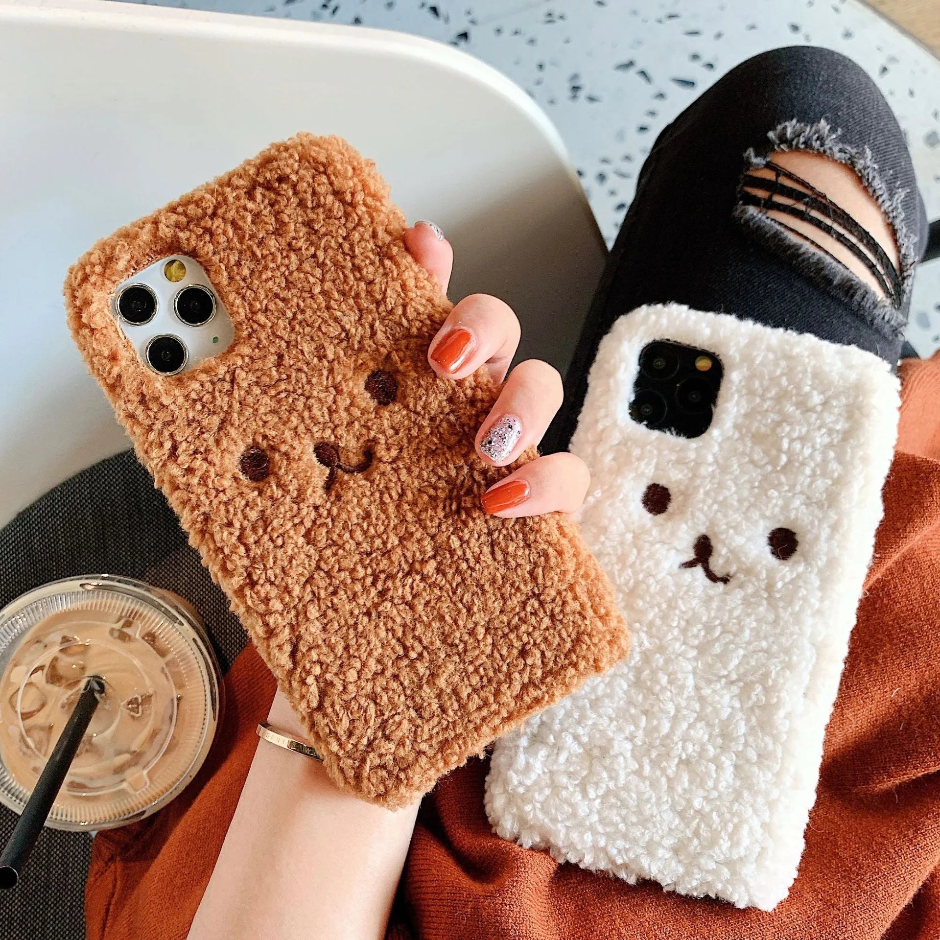 Brown TPU iPhone case with a soft embroidered plush cartoon bear face on the back.