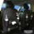 Black PU leather car seat back organiser with multiple pockets and a built-in trash can function.