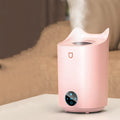 Coral pink USB humidifier with three mist outlets and visible water tank on a bedside table
