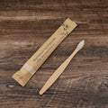 Set of ten bamboo-handled toothbrushes with charcoal bristles in assorted colours on a white background.